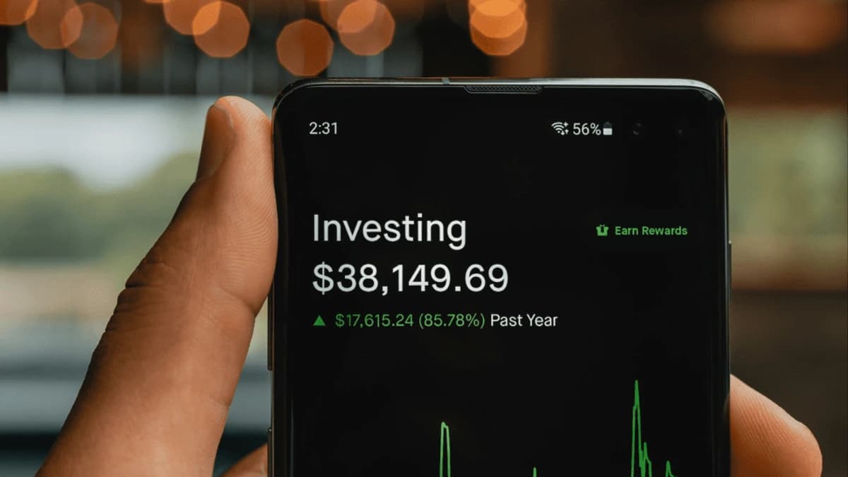 Hand holding a phone displaying an investment portfolio balance