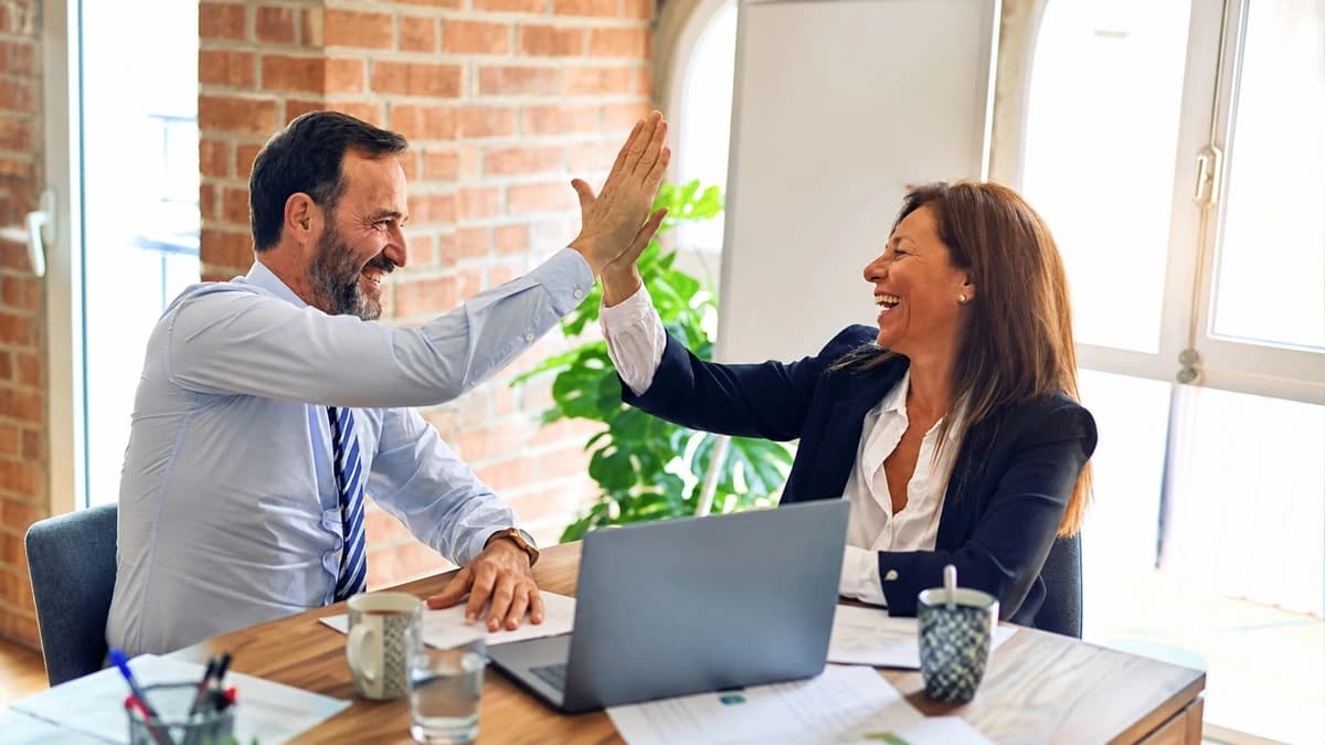Two colleagues celebrating progress with a high five
