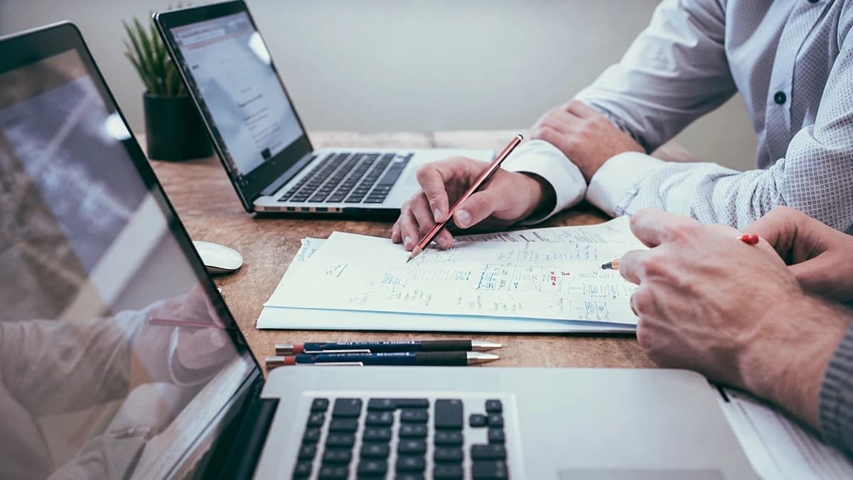 People reviewing a financial plan together between two laptops