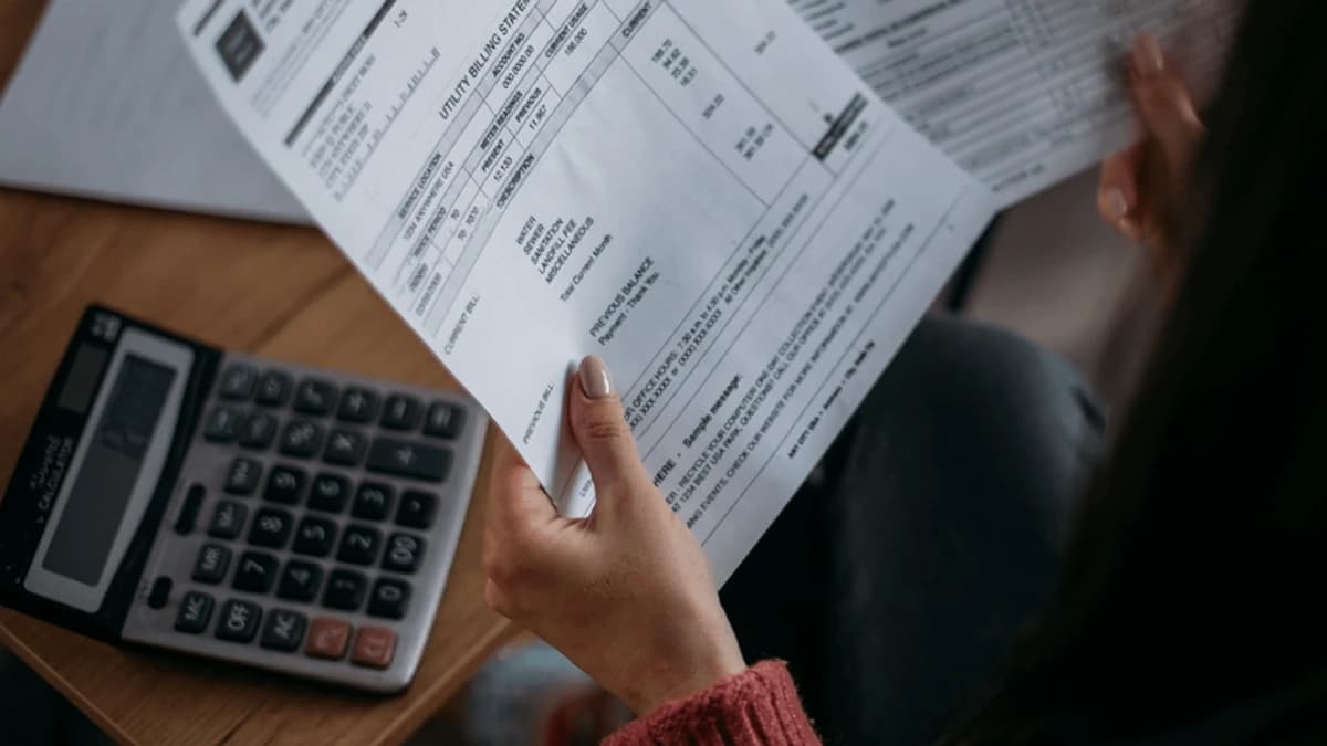 Person reviewing a utility bill with a calculator nearby