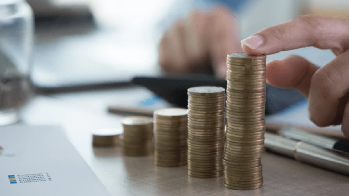 Stacks of coins increasing in height beside a financial chart
